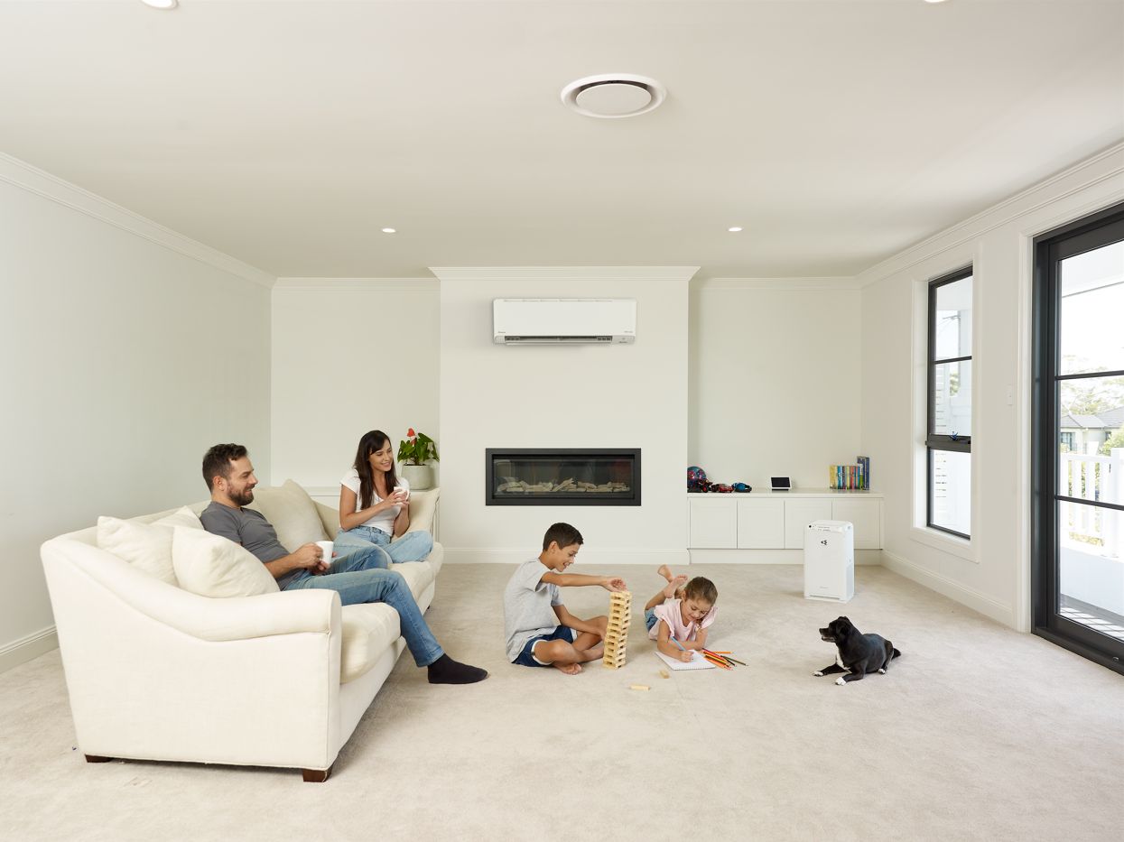 Family relaxing in a living room cooled by a Daikin split system